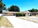 Charming single-story home featuring a wide driveway and well-maintained landscaping under a clear blue sky at 1419 Avenue D Ne, Winter Haven, FL 33881