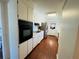 Functional kitchen area with white cabinetry, stainless steel appliances, and wood flooring at 1419 Avenue D Ne, Winter Haven, FL 33881