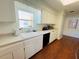 Bright kitchen with white cabinets, a double sink, and wood floors at 1419 Avenue D Ne, Winter Haven, FL 33881