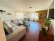 Cozy living room featuring a large sectional sofa, hardwood floors, and plants, creating a comfortable and inviting space at 1419 Avenue D Ne, Winter Haven, FL 33881