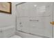 Bright bathroom featuring a shower-tub combo with a glass door, white tile, a new toilet, and a single sink vanity at 147 Bridgewater Dr, Davenport, FL 33897
