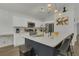 Modern kitchen with white cabinets, stainless steel appliances, quartz countertops, and stylish pendant lighting at 147 Bridgewater Dr, Davenport, FL 33897