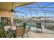 Screened-in pool with a table and chairs, an outdoor ceiling fan, and green hedges surrounding the pool at 147 Bridgewater Dr, Davenport, FL 33897