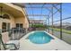 Screened-in pool with a pool safety fence, green hedges, and a covered seating area at 147 Bridgewater Dr, Davenport, FL 33897