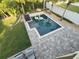 Aerial view of the pool with sun shelf, flamingo floaties, and well-manicured backyard at 14963 Yorkshire Run Dr, Orlando, FL 32828
