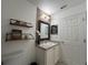 This is a well-lit bathroom with shelves, a vanity, a sink, and a mirror at 14963 Yorkshire Run Dr, Orlando, FL 32828