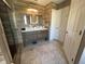 Stylish bathroom showcasing a double sink vanity, large tile flooring, and glass shower doors at 14963 Yorkshire Run Dr, Orlando, FL 32828