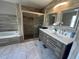 Modern bathroom features a double vanity, tiled floors, and glass shower with decorative tile accent at 14963 Yorkshire Run Dr, Orlando, FL 32828