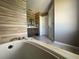 A relaxing bathtub with a view of the vanity and shower, creating a spa-like bathroom at 14963 Yorkshire Run Dr, Orlando, FL 32828