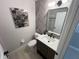 Stylish half bath featuring modern fixtures, appealing wall art and a beautiful herringbone accent wall at 14963 Yorkshire Run Dr, Orlando, FL 32828