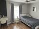 Cozy bedroom with hardwood floors, a desk area, and a window with natural light at 14963 Yorkshire Run Dr, Orlando, FL 32828