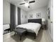 Well-lit bedroom featuring light gray walls, window with curtains, fan, and bench offering a cozy and inviting space at 14963 Yorkshire Run Dr, Orlando, FL 32828