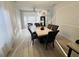 Contemporary dining room featuring a stylish light fixture, a marble-top table, and views of the staircase and seating area at 14963 Yorkshire Run Dr, Orlando, FL 32828