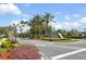 Community entrance featuring a stone sign, manicured landscaping, and palm trees, creates an inviting atmosphere at 14963 Yorkshire Run Dr, Orlando, FL 32828