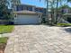 Two-story home with brick paved driveway and attached garage, showcasing curb appeal and practical design at 14963 Yorkshire Run Dr, Orlando, FL 32828