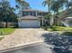Charming two-story home featuring a paved driveway, a well-manicured lawn, and an attached two-car garage at 14963 Yorkshire Run Dr, Orlando, FL 32828