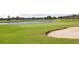 Scenic golf course view featuring a sand trap and putting green beside a lake, offering a recreational lifestyle at 14963 Yorkshire Run Dr, Orlando, FL 32828