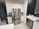 The kitchen features stainless steel refrigerator and ample storage in the bright white cabinetry at 14963 Yorkshire Run Dr, Orlando, FL 32828