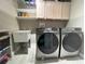 This is a laundry room with gray cabinets, a utility sink, and washer and dryer at 14963 Yorkshire Run Dr, Orlando, FL 32828