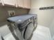 Neutral laundry room with Samsung washer and dryer next to mounted coat rack at 14963 Yorkshire Run Dr, Orlando, FL 32828