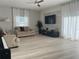 Bright and airy living room with neutral walls, a piano, comfortable couches, and large windows filling the room with sunlight at 14963 Yorkshire Run Dr, Orlando, FL 32828