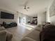Sun-filled open floor plan with tile flooring connecting the living space to kitchen with a large entertainment center at 14963 Yorkshire Run Dr, Orlando, FL 32828