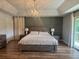 Main bedroom featuring wood floors, tray ceilings, and a walk-out balcony at 14963 Yorkshire Run Dr, Orlando, FL 32828