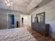 Bright main bedroom featuring wood floors, tray ceilings, and dresser with a full view mirror at 14963 Yorkshire Run Dr, Orlando, FL 32828