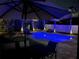 Relaxing outdoor pool area illuminated at night, surrounded by lush tropical landscaping and inviting patio seating at 14963 Yorkshire Run Dr, Orlando, FL 32828