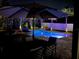 Inviting outdoor pool area lit up at night, surrounded by lush tropical landscaping and lounge chairs at 14963 Yorkshire Run Dr, Orlando, FL 32828