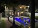 Stunning backyard pool view at night, showcasing palm trees and exterior of the home at 14963 Yorkshire Run Dr, Orlando, FL 32828