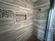 Tiled shower with a built-in niche and decorative tile band for a modern look at 14963 Yorkshire Run Dr, Orlando, FL 32828