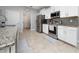 Well-equipped kitchen features stainless steel appliances, white cabinets, and granite countertops at 1557 Alligator St, St Cloud, FL 34771