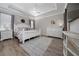 Bright main bedroom boasts a tray ceiling, crown molding, and wood-look floors at 1557 Alligator St, St Cloud, FL 34771