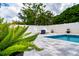 Beautiful in-ground pool with white fence and stone paver surround for outdoor enjoyment at 1557 Alligator St, St Cloud, FL 34771