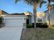 Charming single-story home featuring a gray facade, two-car garage, and well-maintained landscaping at 1574 Thetford Cir, Orlando, FL 32824