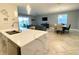 Open-concept living area with kitchen island, dining space, and sliding glass doors to the lanai at 1574 Thetford Cir, Orlando, FL 32824