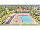 Aerial view of a large pool and clubhouse surrounded by green lawns, palm trees and lounge chairs at 1574 Thetford Cir, Orlando, FL 32824