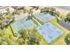 Aerial view showcasing community tennis and basketball courts surrounded by trees and a parking lot at 1574 Thetford Cir, Orlando, FL 32824
