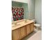 Bathroom with double sinks, wood cabinets, floral shower curtain, and a toilet at 15851 Woodland Spring Ct, Orlando, FL 32828