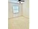 Bedroom with neutral carpet, ceiling fan, and large window at 15851 Woodland Spring Ct, Orlando, FL 32828