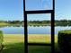 Screen view of serene lake with mirrored reflections, lush greenery, and clear blue sky for a tranquil setting at 15851 Woodland Spring Ct, Orlando, FL 32828