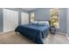 Comfortable bedroom with a plush blue comforter, natural light, and closet space at 1622 Crystalview Trl, Lakeland, FL 33801