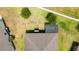 Aerial view of a backyard with lush green grass, two trees, privacy fence, and patio enclosure at 1821 Cayman Cove St., St Cloud, FL 34772