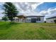 Large backyard featuring a pergola, verdant lawn, storage shed, and neutral-colored exterior at 1821 Cayman Cove St., St Cloud, FL 34772