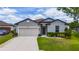 Charming one-story home with a manicured lawn, neutral paint, and an attached two-car garage on a sunny day at 1821 Cayman Cove St., St Cloud, FL 34772