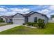 Beautiful single-Gathering home showcasing well-maintained landscaping, a two-car garage, and a welcoming front entrance at 1821 Cayman Cove St., St Cloud, FL 34772