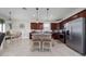 Open-concept kitchen with dark wood cabinetry, granite island with seating, and stainless steel appliances, ideal for gatherings at 1821 Cayman Cove St., St Cloud, FL 34772