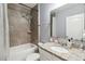 Bathroom featuring tiled shower with sleek fixtures, a white sink vanity and granite countertop at 2281 Canyon Breeze Ave, Kissimmee, FL 34746