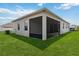 Exterior shot of the house showing the screened in patio and a lush green lawn, perfect for outdoor enjoyment at 2281 Canyon Breeze Ave, Kissimmee, FL 34746